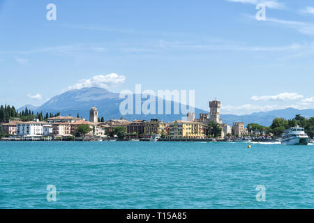 Vue sur le Lac de Garda Sirmione avec montagnes en arrière-plan. Sirmione est ville médiévale située sur la péninsule de Sirmio du Lac de Garde, Italie. Banque D'Images