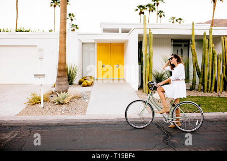 USA, California, Palm Springs, femme à bicyclette dans la rue Banque D'Images