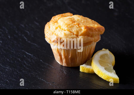 Muffin citron frais sur l'ardoise noire avec les tranches de citron Banque D'Images