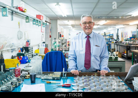 Un monsieur plus âgé / business owner standing dans et sur le sol de l'usine de son entreprise de fabrication traditionnel entouré par des outils Banque D'Images