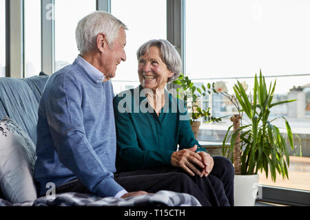 Rire senior couple sitting on couch ensemble Banque D'Images