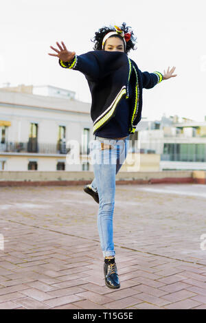 Portrait of happy young woman jumping dans la ville Banque D'Images