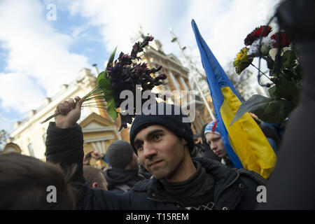 Kiev, Kiev, Ukraine. Mar 23, 2019. Un manifestant vu jeter des bouquets de fleurs en plastique sur les policiers en tenue de combat à l'extérieur de l'Administration présidentielle, pendant la manifestation. Les manifestants se sont réunis à la place puis ont défilé jusqu'au bâtiment de l'Administration présidentielle d'appeler Président Petro Poroshenko à apporter à la justice les responsables gouvernementaux corrompus. Avec les élections présidentielles en Ukraine qui se tiendra à la fin de mars, les tensions politiques sont très élevés. Crédit : Matthieu Hatcher SOPA/Images/ZUMA/Alamy Fil Live News Banque D'Images