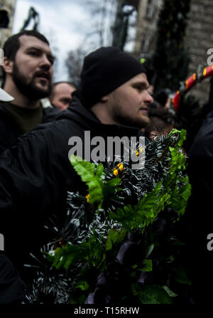 Kiev, Kiev, Ukraine. Mar 23, 2019. Un manifestant vu jeter des bouquets de fleurs en plastique sur les policiers en tenue de combat à l'extérieur de l'Administration présidentielle, pendant la manifestation. Les manifestants se sont réunis à la place puis ont défilé jusqu'au bâtiment de l'Administration présidentielle d'appeler Président Petro Poroshenko à apporter à la justice les responsables gouvernementaux corrompus. Avec les élections présidentielles en Ukraine qui se tiendra à la fin de mars, les tensions politiques sont très élevés. Crédit : Matthieu Hatcher SOPA/Images/ZUMA/Alamy Fil Live News Banque D'Images