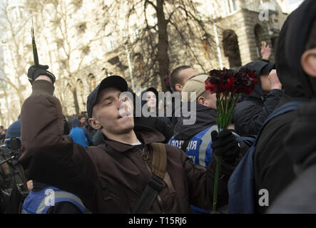 Kiev, Kiev, Ukraine. Mar 23, 2019. Un manifestant vu jeter des bouquets de fleurs en plastique sur les policiers en tenue de combat à l'extérieur de l'Administration présidentielle, pendant la manifestation. Les manifestants se sont réunis à la place puis ont défilé jusqu'au bâtiment de l'Administration présidentielle d'appeler Président Petro Poroshenko à apporter à la justice les responsables gouvernementaux corrompus. Avec les élections présidentielles en Ukraine qui se tiendra à la fin de mars, les tensions politiques sont très élevés. Crédit : Matthieu Hatcher SOPA/Images/ZUMA/Alamy Fil Live News Banque D'Images