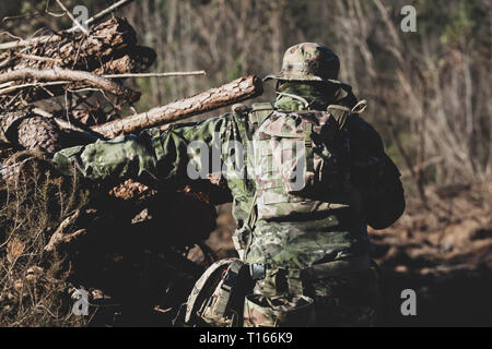 Joueur de jeu militaire Airsoft des uniformes de camouflage avec Armed Assault Rifle. Banque D'Images