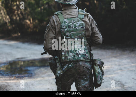 Joueur de jeu militaire Airsoft des uniformes de camouflage avec Armed Assault Rifle. Banque D'Images