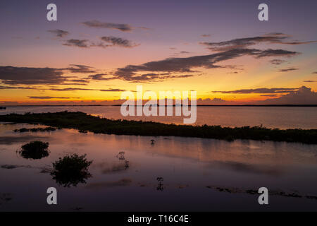 Le soleil se couche sur la baie de Chetumal sur Ambergris Caye, Belize casting teintes brillantes dans le ciel et se reflétant dans les eaux a ondulé par une brise chaude. Banque D'Images