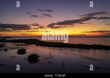 Le soleil se couche sur la baie de Chetumal sur Ambergris Caye, Belize casting teintes brillantes dans le ciel et se reflétant dans les eaux a ondulé par une brise chaude. Banque D'Images