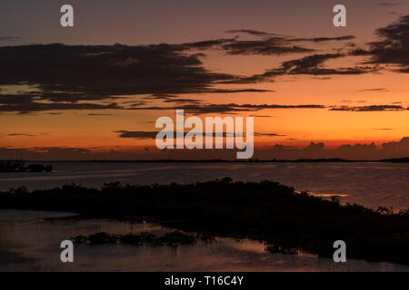 Le soleil se couche sur la baie de Chetumal sur Ambergris Caye, Belize casting teintes brillantes dans le ciel et se reflétant dans les eaux a ondulé par une brise chaude. Banque D'Images