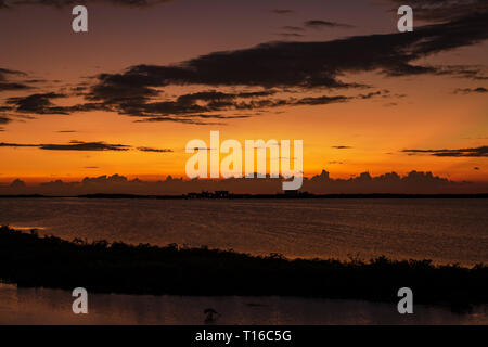 Le soleil se couche sur la baie de Chetumal sur Ambergris Caye, Belize casting teintes brillantes dans le ciel et se reflétant dans les eaux a ondulé par une brise chaude. Banque D'Images