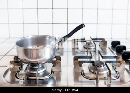 Gros plan du sol carrelé retro vintage propre cuisinière à gaz haut avec tuiles de comptoir blanc et en acier inoxydable pot cooking in kitchen Banque D'Images