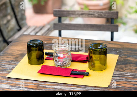 Gros plan de l'Italie de lunettes à l'envers sur la table à l'extérieur restaurant vide dans un style traditionnel street cafe assise en bois journée romantique Banque D'Images