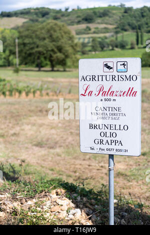 Montalcino, Italie - 26 août 2018 : Campagne du Val D'Orcia en Toscane avec des sols bruns paysage agricole winery vineyard avec signe de l'agriturismo brune Banque D'Images