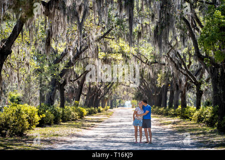 Street road paysage avec chemin des chênes à Savannah, Géorgie célèbre cimetière Bonaventure avec mousse espagnole et les jeunes heureux couple romantique Banque D'Images