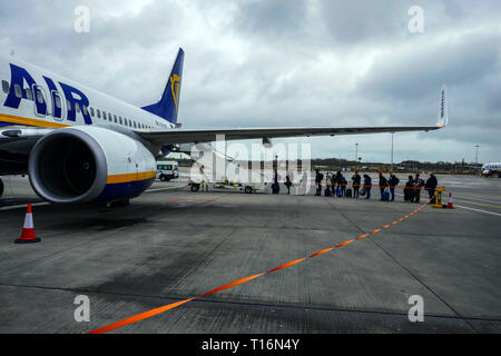 Les gens d'attente, le budget Ryanair transporteur, Boeing 737, compagnie aérienne, l'aéroport de Stansted, Londres, UK Banque D'Images