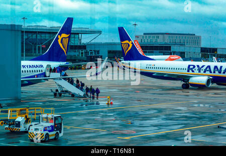 Les gens d'attente, le budget Ryanair transporteur, Boeing 737, compagnie aérienne, l'aéroport de Stansted, Londres, UK Banque D'Images