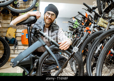 Portrait d'un homme élégant avec vélo pliant au Bicycle shop Banque D'Images