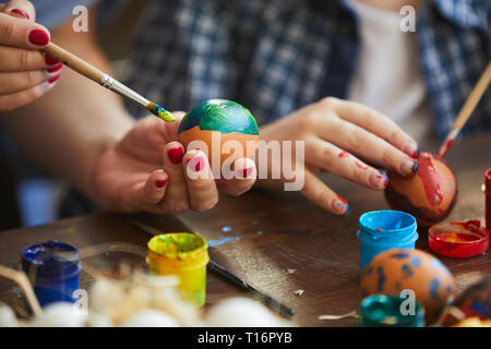 La mère et l'enfant peindre des oeufs de Pâques Banque D'Images