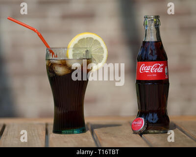 Menen, BELGIQUE - 17 MAI 2017 : une bouteille de coca cola à côté d'un verre de coke, rempli de glaçons et une tranche de citron. Banque D'Images