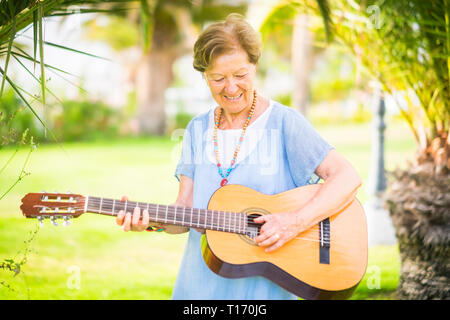 Joyeux et heureux ancien portrait of Smiling et s'amuser jouant de la guitare et de dong music en extérieur parc activité de loisirs - retraité Banque D'Images