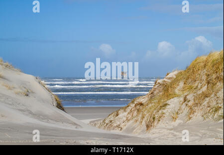 La plate-forme de production en mer près de l'île néerlandaise d'Ameland, dunes, plage et vagues à l'avant-plan Banque D'Images