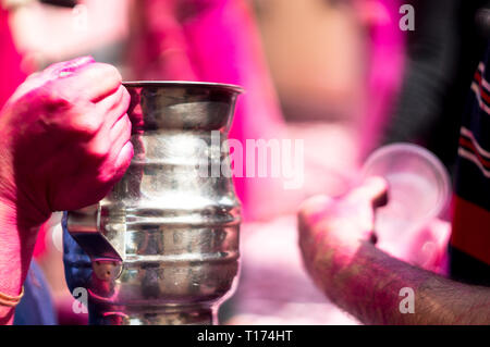 Colorful hands holding tasses jetables de thandai sur holi festival hindou Banque D'Images