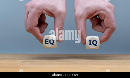 Symbole de l'équilibre entre l'intelligence émotionnelle et le quotient intellectuel. Les mains tenant deux dés avec les lettres 'EQ' et 'IQ' en face Banque D'Images