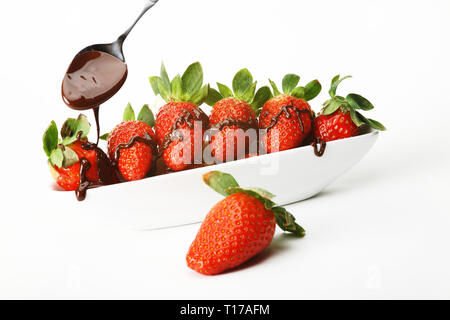 Un bol de fraises couvertes de chocolat. Isolé sur un fond blanc. Banque D'Images