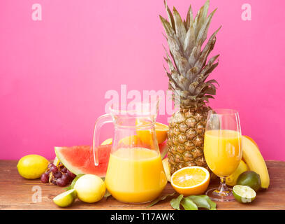Avec un jus de fruits tropicaux sur table en bois Banque D'Images