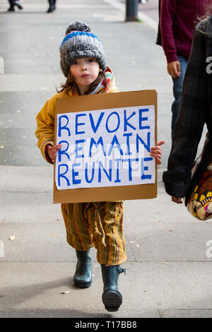 Londres, Royaume-Uni. 23 mars 2019. Un jeune enfant porte une pancarte avec les mots : révoquer, rester, réunir. Restent partisans et des manifestants prendre part à une marche pour arrêter Brexit dans Central Londres appelant à un vote du peuple. Banque D'Images