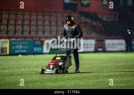 Groundsman entretien terrain de football dans la pluie Banque D'Images