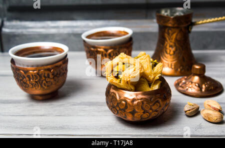 L'arabe baklava dessert avec le café dans des tasses en cuivre Banque D'Images
