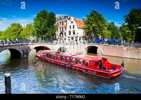 Montez à bord d'un bus à arrêts multiples, excursion en bateau de plaisance à travers les canaux d'Amsterdam sur le point de passer sous le pont voûté très bas, Hollande, pays-Bas, Europe. Banque D'Images