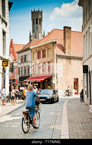Femme seule à vélo vers sur la voiture à venir, petite rue latérale loin de la caméra, bruges, Belgique, Europe, Banque D'Images