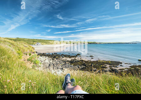 Allongé sur l'herbe sur le haut de la falaise admiring view de Whitesands Beach à Pembrokeshire, Pays de Galles Banque D'Images