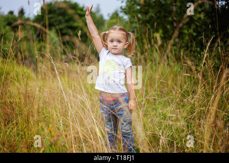 Portrait of cute little girl à l'extérieur. Kid palying dans parc, jardin, prairie. Le bonheur. Les enfants d'âge préscolaire en bonne santé l'activité d'été Banque D'Images