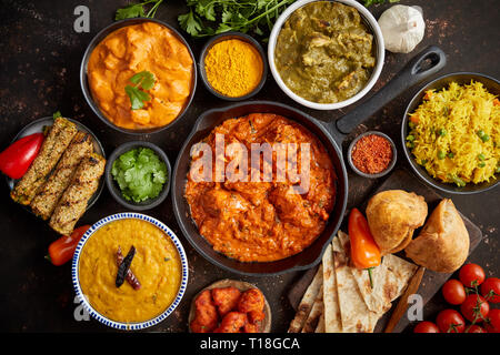 Assortiment de différents types de cuisine indienne sur rusty sombre tableau. Poulet Tikka Masala, beurre, Nilgiri, Tarka Daal. Servi avec du riz frit, naan bre Banque D'Images