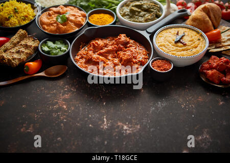 Assortiment de différents types de cuisine indienne sur rusty sombre tableau. Poulet Tikka Masala, beurre, Nilgiri, Tarka Daal. Servi avec du riz frit, naan bre Banque D'Images