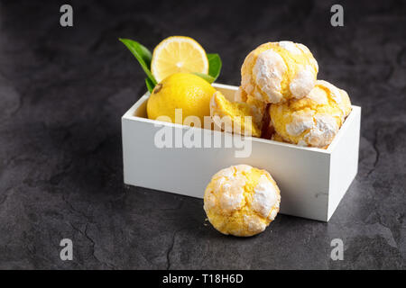 Cookies citron fraîchement soutenue sur la petite boîte blanche sur fond sombre Banque D'Images