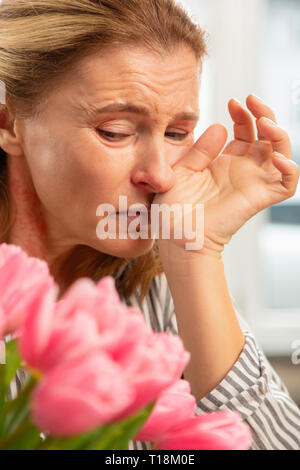 Femme mature sentiment horrible après recevoir des fleurs de la bien-aimée Banque D'Images