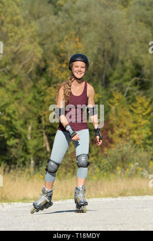 Jeune femme patin à roues alignées, à la fin de l'été Banque D'Images