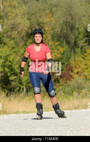 Jeune femme patin à roues alignées, à la fin de l'été Banque D'Images