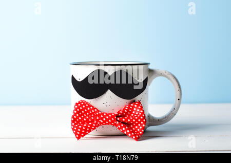 Tasse à café avec moustache et Noeud Papillon rouge sur fond bleu, Happy Father's Day Concept Banque D'Images