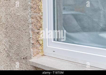Close-up d'une fenêtre dans le shell avec mousse de construction et d'appui de fenêtre, Allemagne Banque D'Images