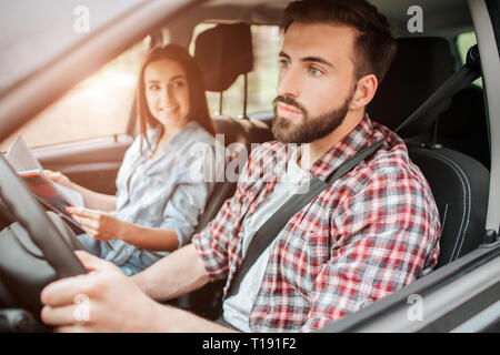 Attention et nice guy est le moteur de voiture et à la ligne droite. Il paie la totalité de son attention sur la route. Fille est assis en dehors de lui. Elle est h Banque D'Images