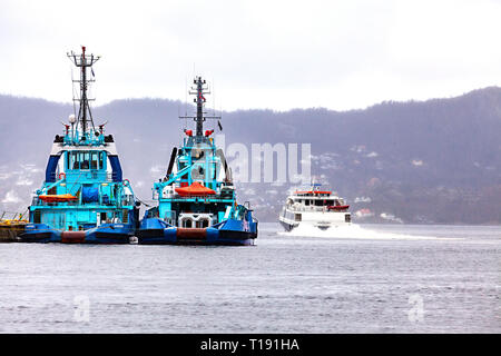 Deux remorqueurs Vivax et silex amarré à Tollbodkaien dans le port de Bergen, Norvège. Derrière, catamaran à passagers à grande vitesse sur Ekspressen c'est sortie. Banque D'Images