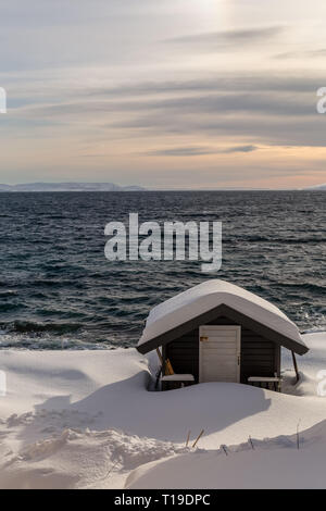 Un petit bâtiment en bois couvert de neige dans la ville portuaire de Honningsvag en Norvège. Banque D'Images