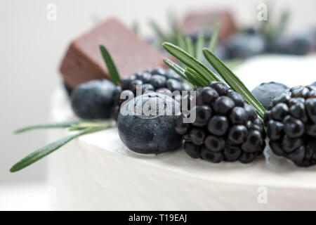 La décoration de gâteau avec blueberry et blackberry avec le romarin. Cake Shop concept. Gâteau de mariage close-up. Gâteau d'anniversaire. Banque D'Images