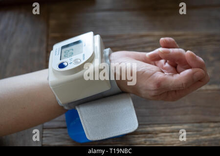 Femme d'âge moyen prend sa pression artérielle à domicile Banque D'Images